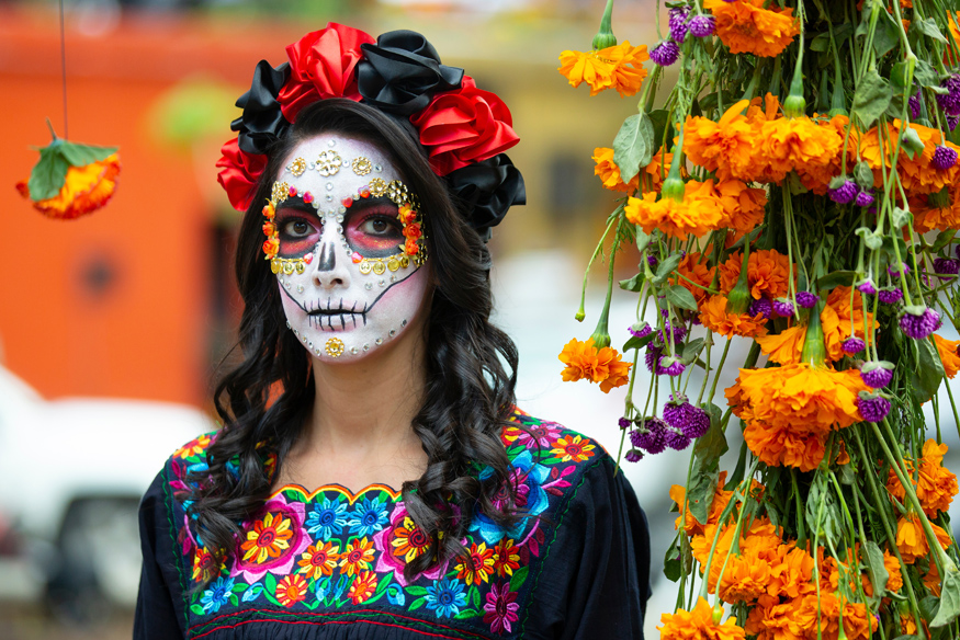 Eine Frau in Maya Tracht und traditionell geschminkt am Dia de los Muertos in Yucatan Mexiko.