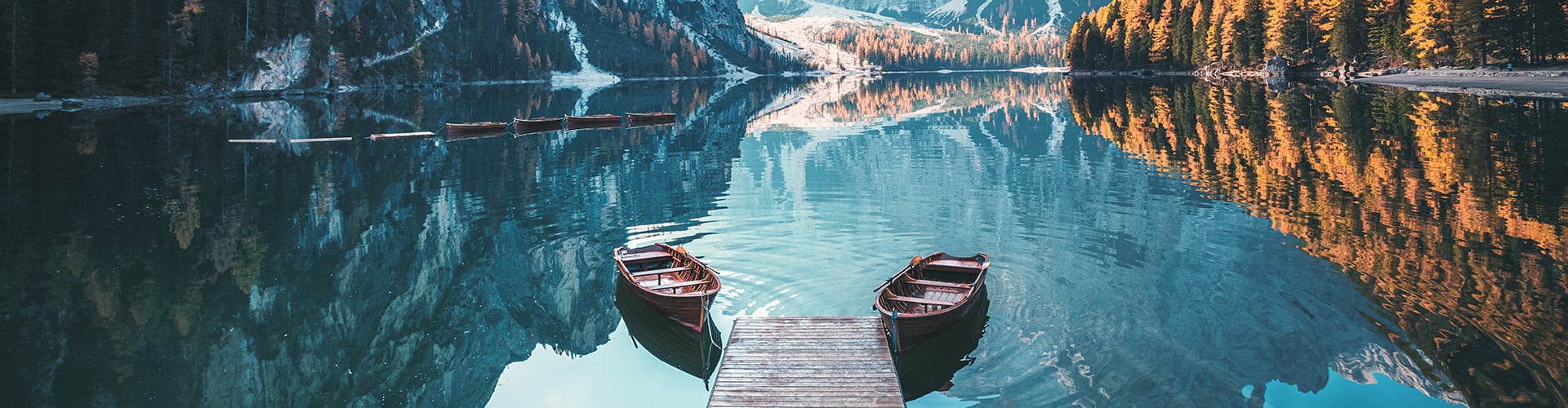 doa barci pe un lac, imagine intre munti si padure.